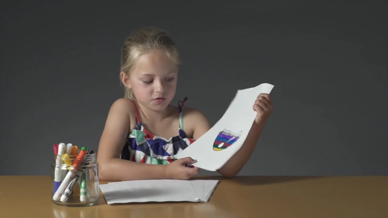 A girl shows her breakfast drawing to the camera